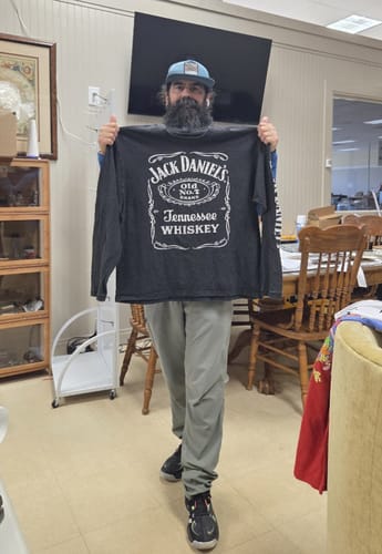 Reviewer holding up a black Jack Daniel's long-sleeve shirt, one of the Wholesale Beverage T-shirts.
