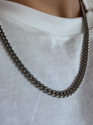 Primer plano de un cliente usando la Cadena Miami Cuban sobre una camiseta blanca.