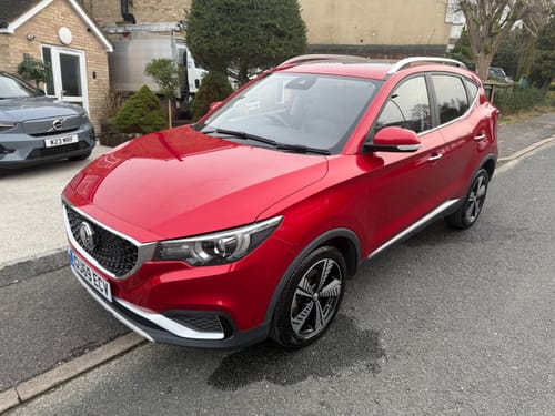 Customer's shiny red car parked on a street after being cleaned with The Apex Warrior Kit.