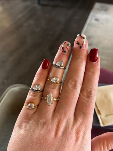 Reviewer's hand displaying two gold and two silver Pia Rings across multiple fingers, alongside another ring.