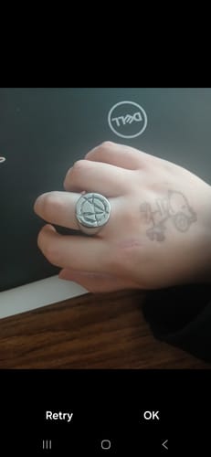 A close-up of a reviewer's hand wearing the silver ANARCHY SIGNET RING.
