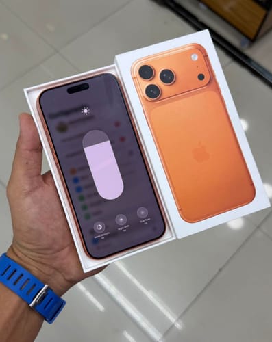 Reseñador sosteniendo su IPHONE 17 PRO MAX color naranja en la caja abierta.