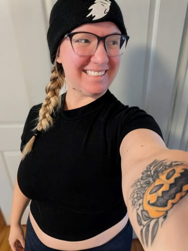 Reviewer in a selfie wearing the short-sleeved Bad Girl Crop Top in black, showing its form-fitting, cropped style.