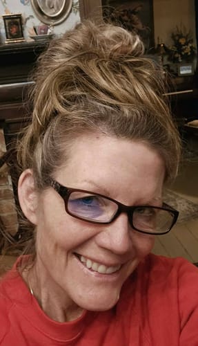 Customer smiling while wearing the JuvaBun Straight Hair Bun in a full, messy top knot style.