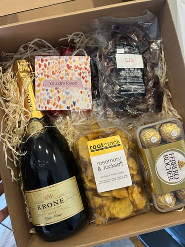 Customer's unboxed Krone & Crisp Exquisite Snack Hamper showing the wine, crisps, chocolates, and packaged biltong.