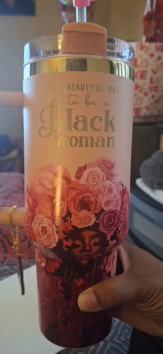 Customer holds the rose pink 'Royalty Blossomed' tumbler, showing the gold text and floral illustration.