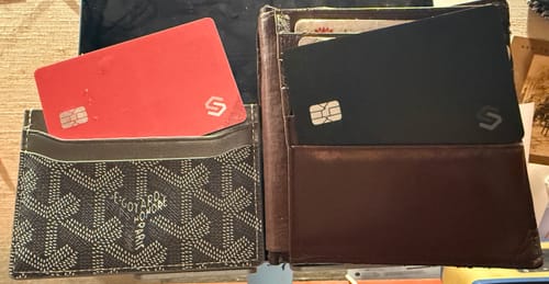 Customer shows a red SPOTMINDERS tracking card in a cardholder and a black card in a bifold wallet.