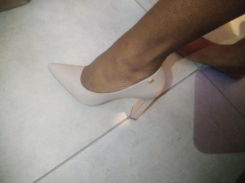Close-up of a reviewer's foot wearing the nude Miss Black Nala 2 Court heel indoors on a tiled floor.