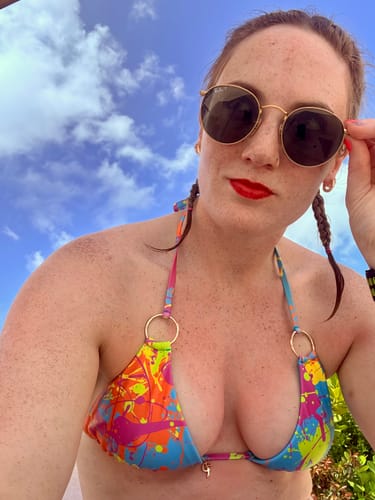 Close-up of a reviewer outdoors wearing the vibrant Wild Splatter Bikini Top.