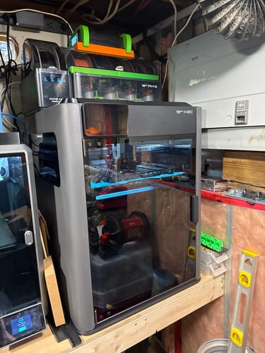 Customer's Bambu Lab H2C AMS Combo printer set up on a workbench in a workshop.