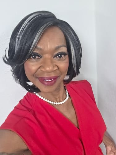 Reviewer wearing the Outre Melted Hairline Wig, a short black bob with bold silver highlights in the front.