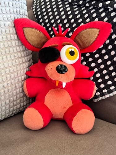 Reviewer's detailed Foxy Plush from FNAF sitting upright on a couch.