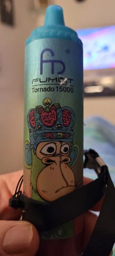 Ein Kunde hält den blauen RANDM TORNADO 15000 Vape mit einer Cartoon-Affen-Grafik in der Hand.