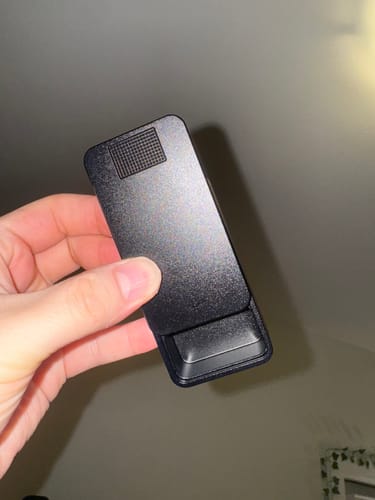 Reviewer holding the black metal pill case with the sliding top partially open.