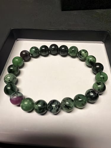 Photo d'un client du bracelet Rubis Zoïsite. Les perles rondes sont vertes, noires et roses, dans leur boîte.