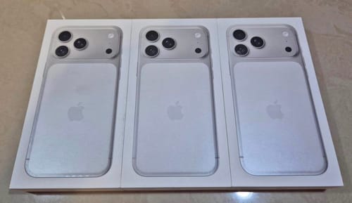 Cliente muestra la parte trasera de tres IPHONE 17 PRO MAX plateados en sus cajas abiertas.