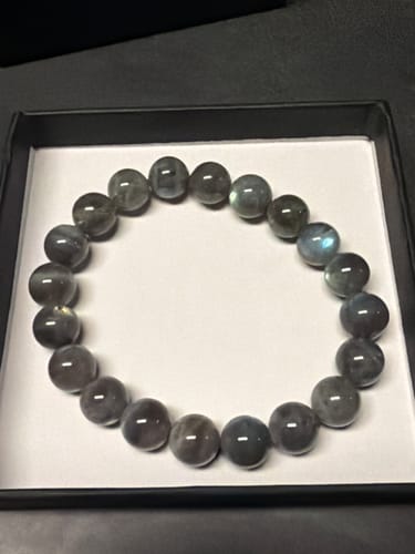 Avis d'un client sur le bracelet en labradorite véritable, dont les perles grises sont présentées dans un écrin noir.