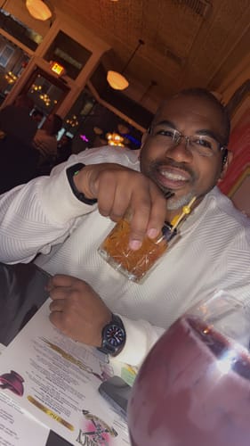 Customer's partner smiling in a restaurant, celebrating the anniversary mentioned in the review.