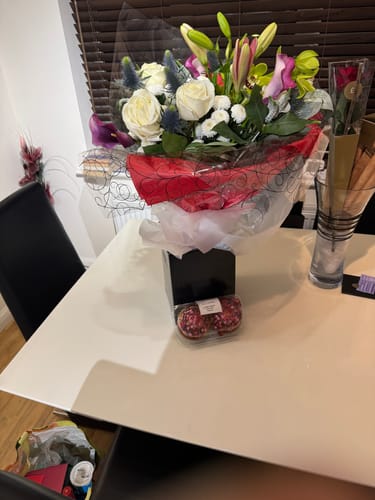 Customer's black presentation box from the Spray Box Set, used to display a large bouquet of flowers on a table.