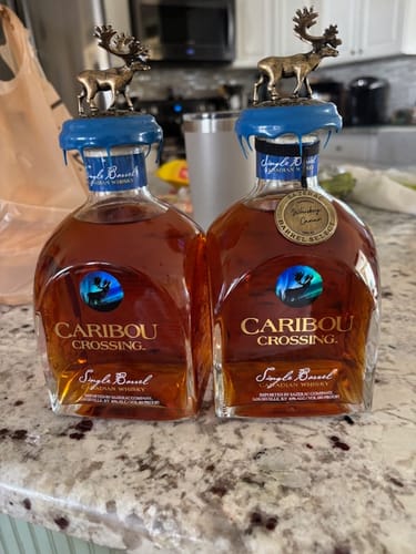 Customer's two bottles of Caribou Crossing whisky, with their distinct caribou stoppers, on a counter.