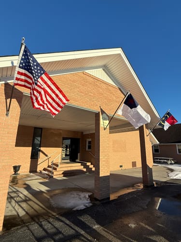 Customer's Prestige House Flag Pole with an American flag installed on the brick entrance of a building.