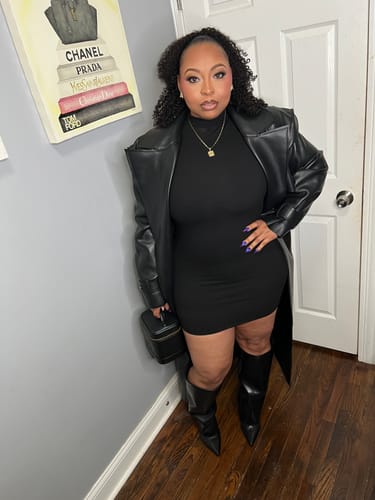 Reviewer posing indoors in the black Vegan Leather Trench Coat, worn open to show the oversized fit and notched collar.