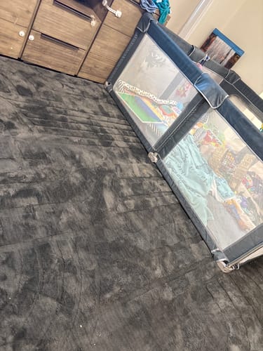 Customer's large charcoal Mellow Mat in a lounge room with a child's playpen placed on top.