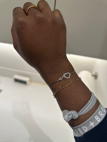 Customer's wrist wearing the delicate To My Daughter - Forever Love Bracelet stacked with other bracelets.