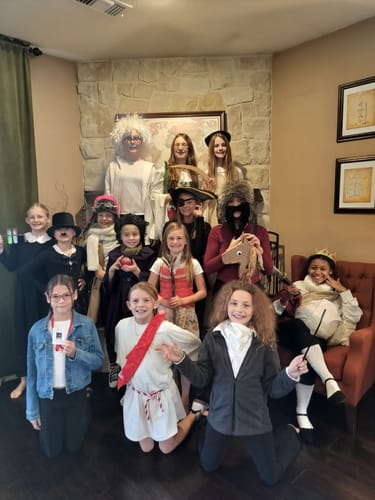 A large group of children posing in various historical costumes for the Kids Murder Mystery Game Kit.