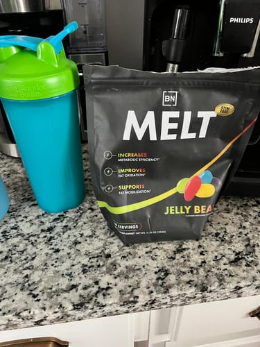 Reviewer's pouch of Melt Jelly Bean stim-free supplement on a counter next to a shaker bottle.