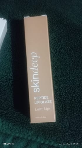 Customer shows the light brown packaging for their Peptide Lip Glaze in the shade 'Latte Lips'.