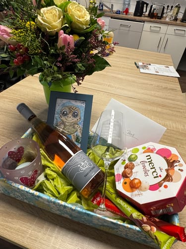 Ein Rezensent zeigt das Leonardo Weinglas in einem schönen Geschenkkorb mit einer Flasche Wein und Schokolade.