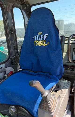 Customer's blue Waterproof Car Towel Seat Cover fitted on the seat inside an excavator cab.