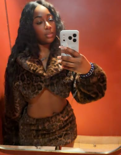 Reviewer in a mirror selfie wearing the Faux Fur Leopard Shrug and matching mini skirt.