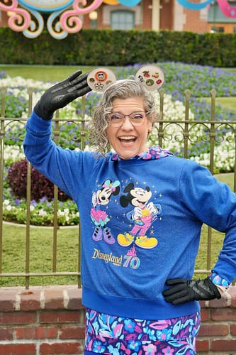 Reviewer layering the Tropiglow Performance Hoodie, with its vibrant floral hood visible over a sweatshirt.