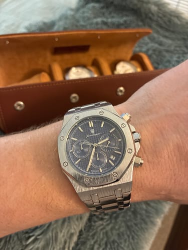 Customer's silver Lucky Fours® Tourbillon watch with a blue chronograph dial, shown on their wrist.