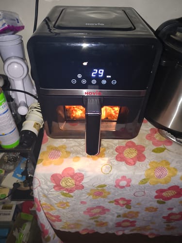 Friteuza neagră Air Fryer Novio StonePro a recenzentului, cu afișajul digital și lumina interioară pornite.
