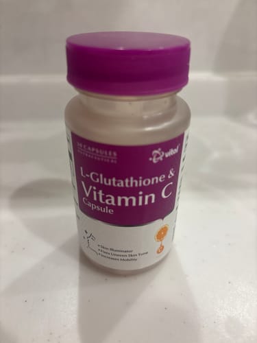 レビューアーが撮影した、白い面に置かれたL-グルタチオン & ビタミンC サプリのボトル。