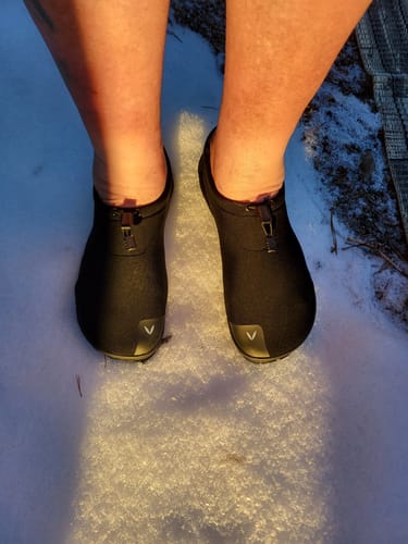 Asiakkaan mustat Vaistoa Vire -avantopaljasjalkakengät jalassa lumessa.