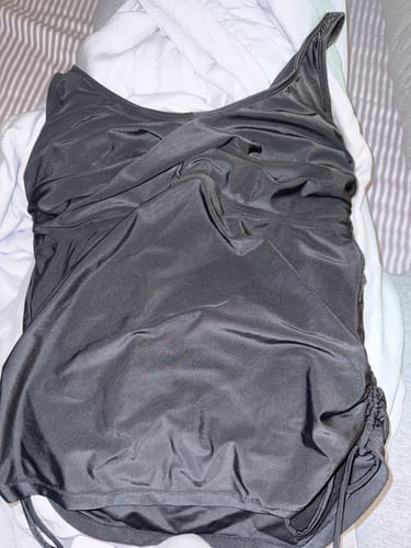 Customer's black Lovemère Swim Tankini top laid out, showing the gathered details on the sides and bust.