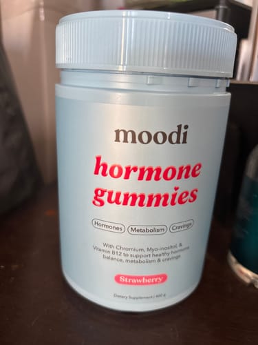 Customer's light blue container of Moodi hormone gummies in the strawberry flavor.