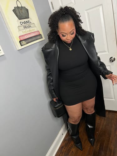 A different view of the reviewer in the black Vegan Leather Trench Coat, showing the notched lapels and oversized structure.
