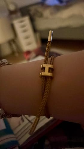 Rezensentin trägt das verstellbare, goldfarbene Golden Harmony Armband an ihrem Handgelenk.