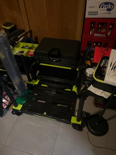 Recensent toont de opgestelde S36 PRO LIME zitkist, met zijn zwarte frame en limoengroene accenten, in een kamer.