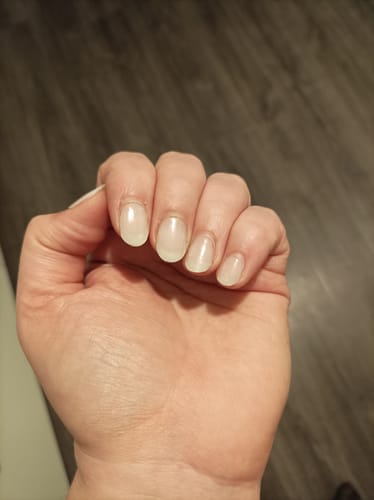 Hand einer Kundin, die die semitransparenten Babyboomer UV Gel-Nagelfolien auf kurzen Nägeln zeigt.
