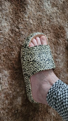 Customer's foot wearing a thick-soled Cloudies™ Orthopedic Slipper in a leopard print pattern.