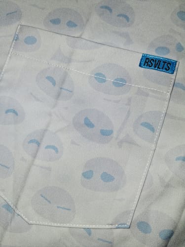 Close-up of the reviewer's WALL-E 'In Your Eyes' shirt pocket, showing the detailed EVE eye pattern and brand tag.