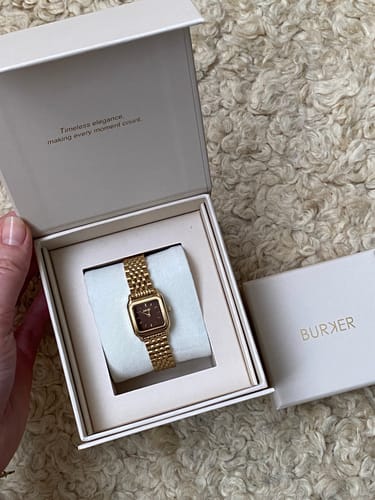 Customer holding the open box for their Macy Petite Gold Brown watch, showing the product nestled inside.