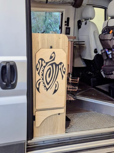 Customer's black Pacific Native Style Turtle Decal applied to a wooden fold-out table inside a van.