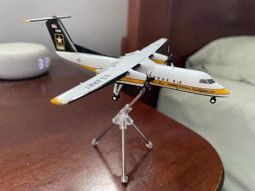 Customer's Gemini200 C-147A Golden Knights model airplane displayed on its stand on a wooden desk.
